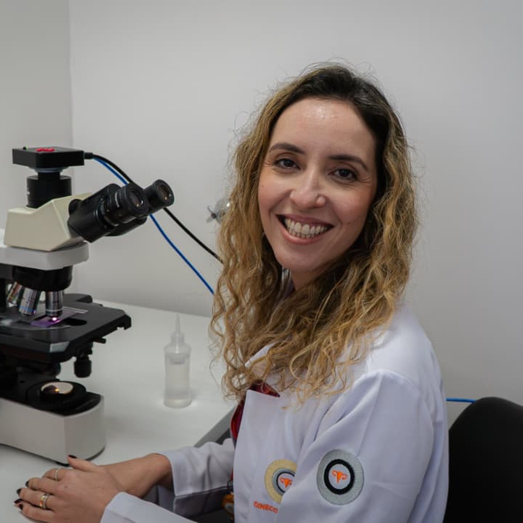 Dra. Talita ao lado do microscópio